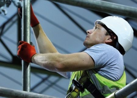 Scaffold operator working on scaffolding wearing PPE on a safe site